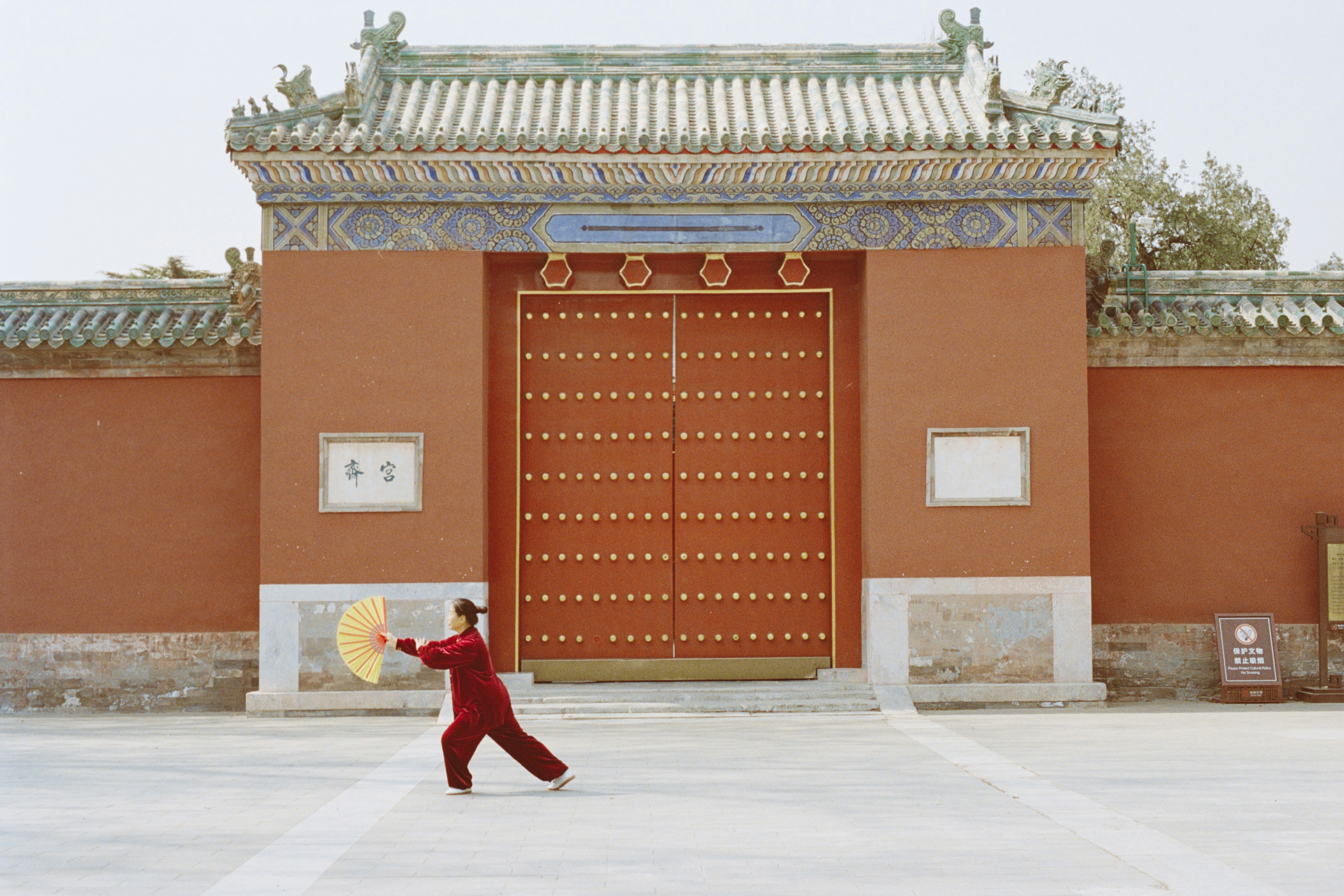 A person practicing tai chi fan form, reflecting the body clock's alignment of practice with organ peak times in Chinese medicine